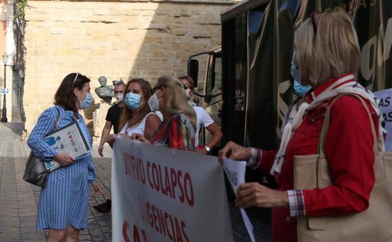 Sara Alba conversa con los trabajadores concentrados en la puerta del Parlamento. 