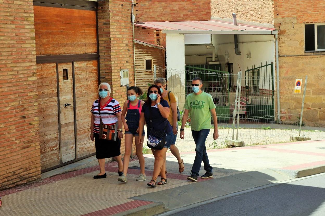 Una familia camina por una calle ayer en Villamediana. 