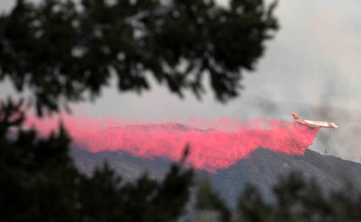 Un avió lanza líquido retardante para tratar de apagar el incendio que afecta el Monte Wilson, en las cercanías de Los Ángeles.