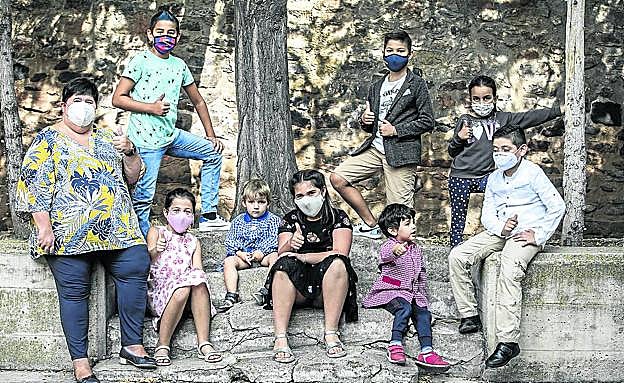 Imagen principal - Susana, David, Chahrazd, Ángela, Gonzalo, Eric, Izure, Miguel y Safouan; Susana toma la temperatura a Izure; y Miguel y Safouan juegan en el aula.