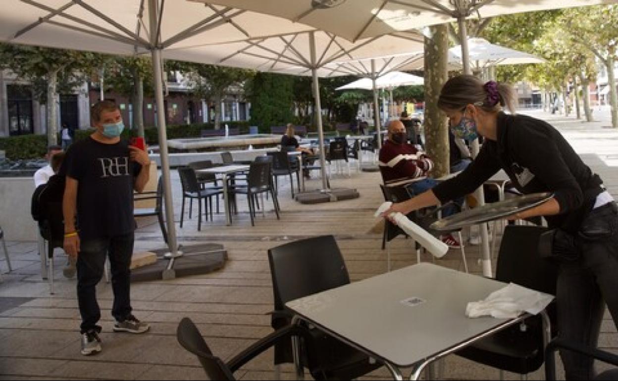 Una camarera prepara la mesa para un cliente en un bar del municipio riojano de Calahorra 