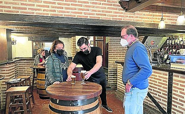Borja García atiende a dos clientes en el restaurante 'El Jarrero'.