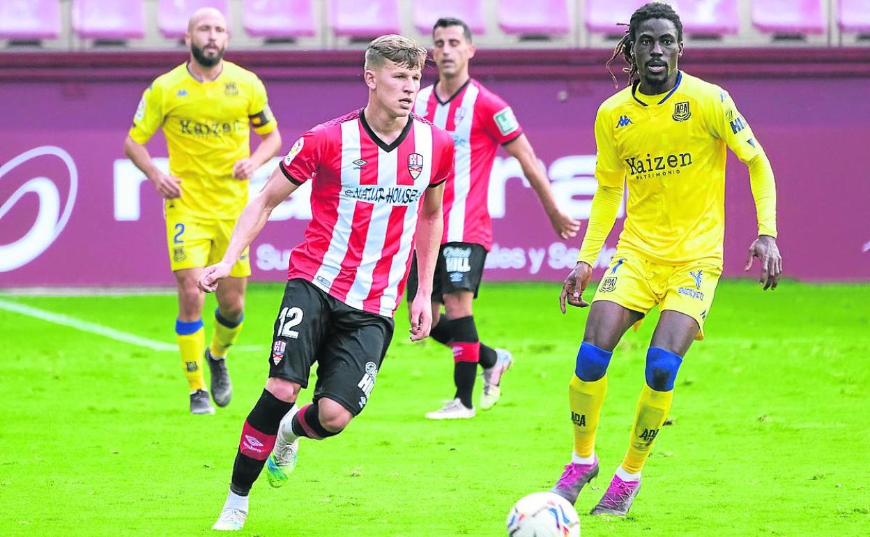 Bogusz avanza con el esférico ante la mirada de Boateng.