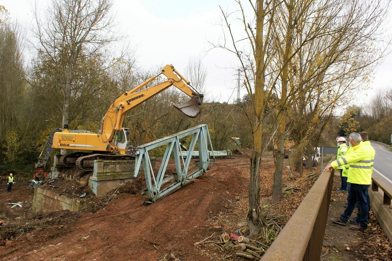 La retroexcavadora retira una de las partes del puente derruido que tal vez puedan salvarse al estar menos dañadas. 