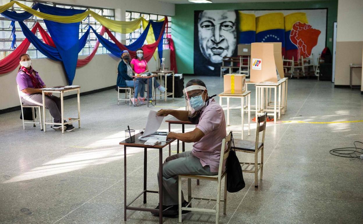 Los responsables de un colegio electoral de Caracas, desocupados por la escasa a asistencia de votantes.