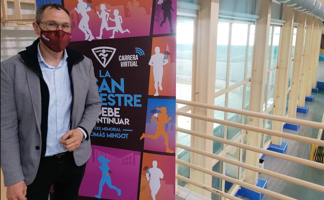 El concejal de Deportes, Rubén Antoñanzas, junto al cartel de la San Silvestre de este año.