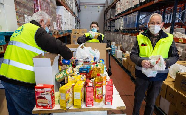 Imagen principal - Sobre estas líneas, José Luis Rodríguez (uno de los veteranos del Banco de Alimentos de La Rioja), Juan Ramón Sáenz y Ángel Nicolas clasifican las cajas donadas por la ONCE y los colegios Rey Pastor, Jesuitas,y el IES Duques de Nájera. Abajo, sede de la Asociación COLOR y parte de los alimentos llegados del Banco de Alimentos y que ya fueron repartidos la semana pasada. En primer plano, su presidenta Domi Vega. 