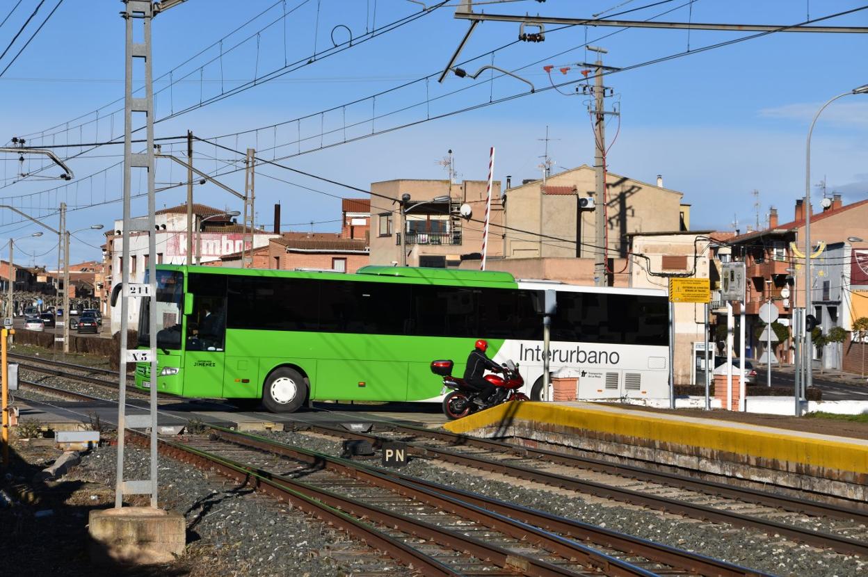 Un autobús de línea cruzando las vías del tren a su paso por Rincón de Soto. 