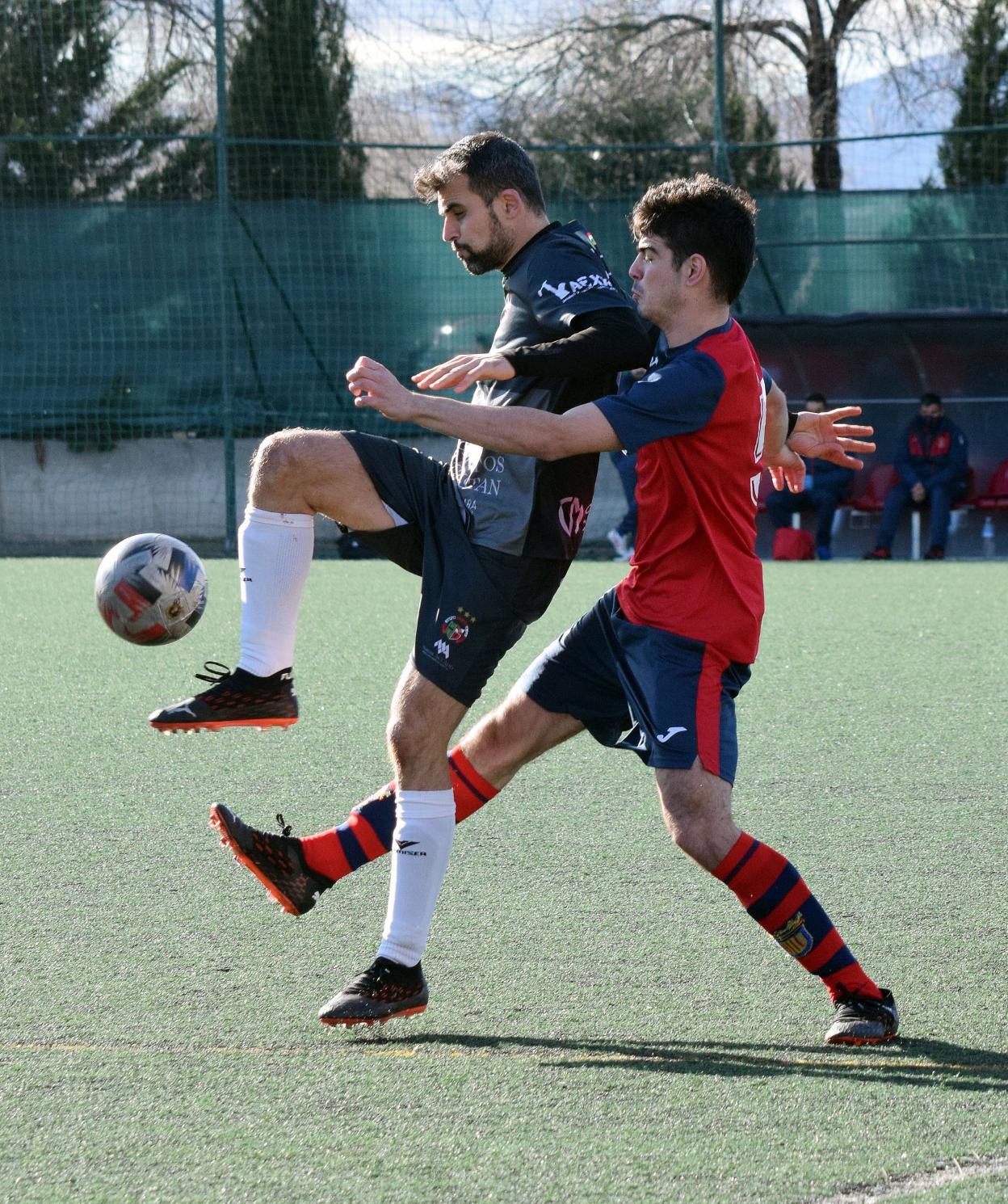 Rubén Pérez juega el balón ante la presión de Portillo. 