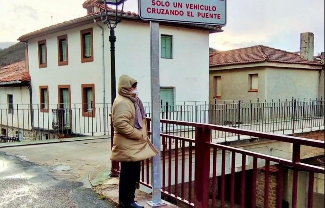 Angélica Calvo observa el puente junto a la nueva señal. 