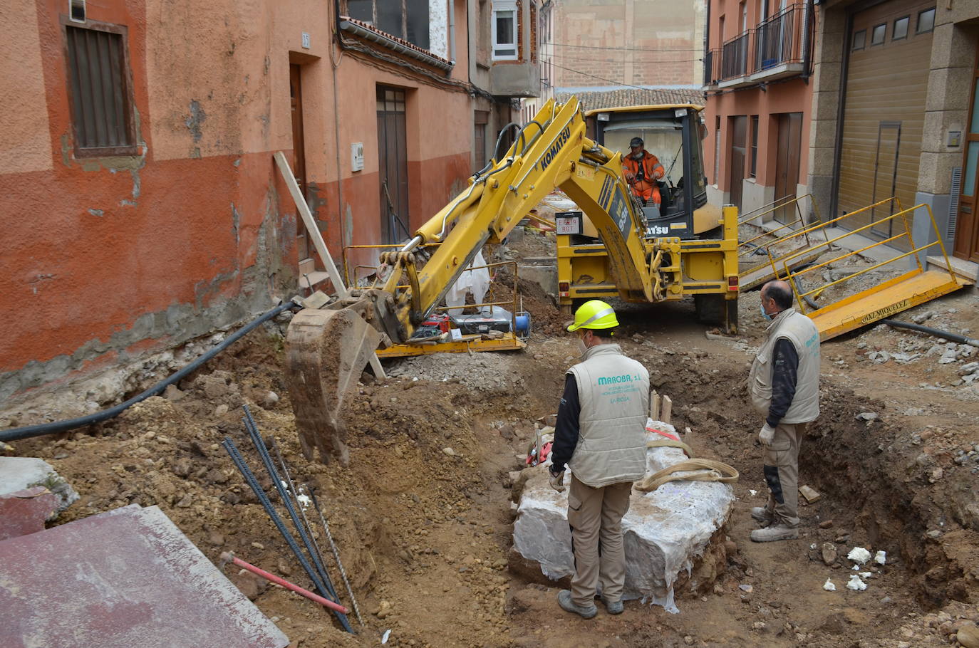 La pala extrae uno de los fragmentos de los resto del desagüe romano. 