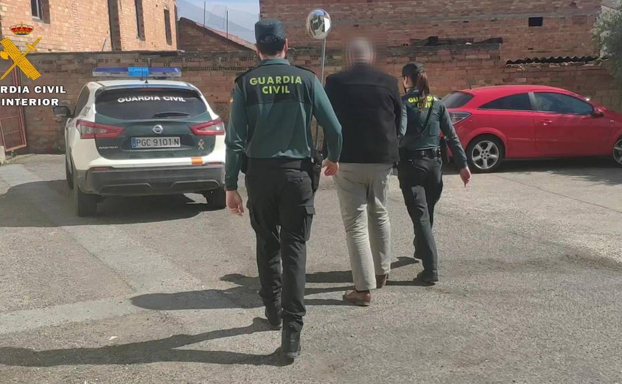 El detenido escoltado por dos agentes en Villamediana. 