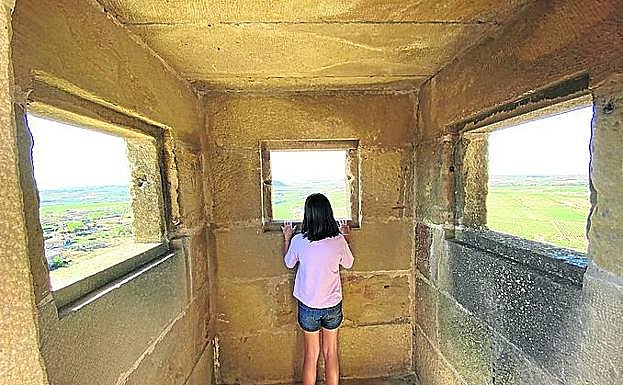 Una niña disfruta de las vistas del conjuratorio del castillo. 