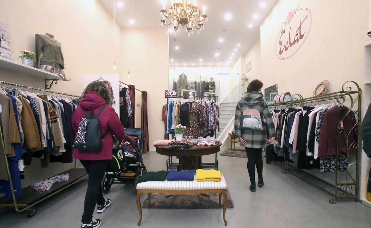 Dos mujeres miran ropa en una tienda de Logroño. 
