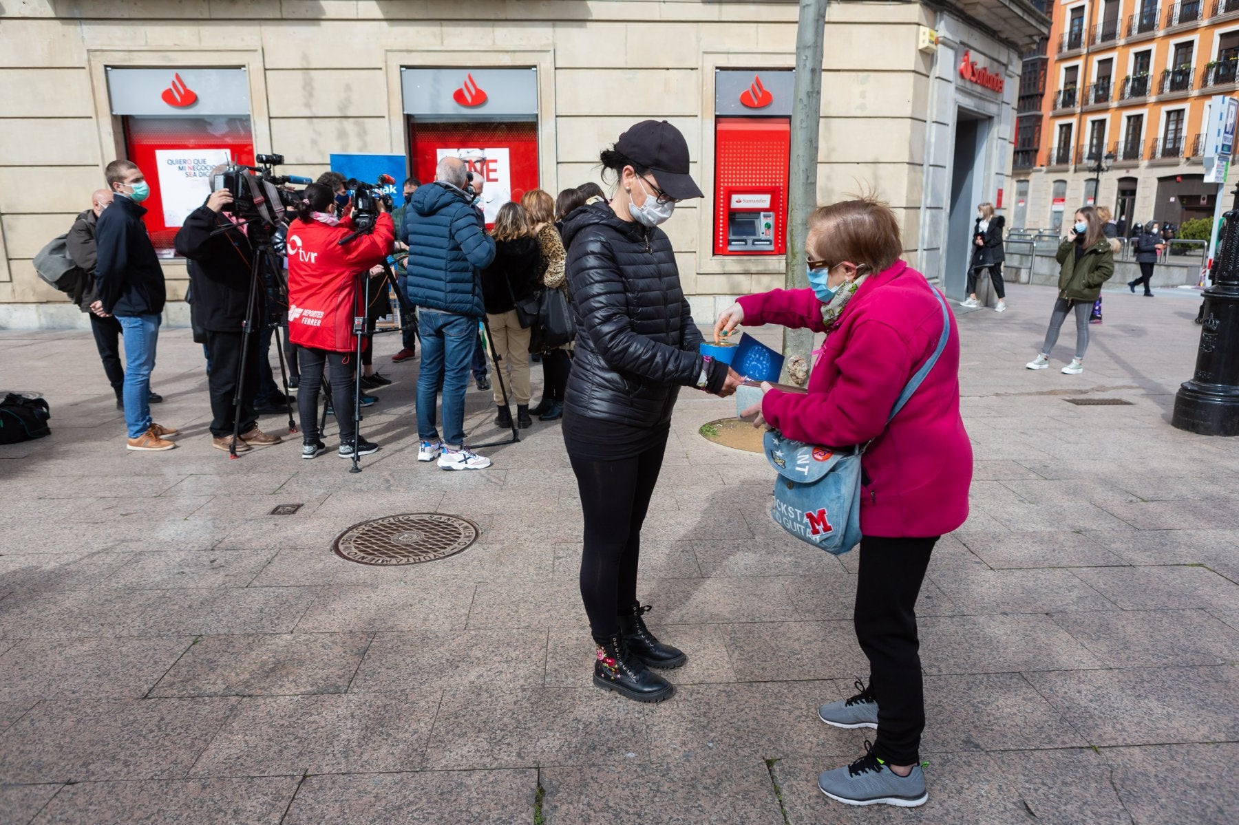 Una vecina de Logroño ofrece su aportación a Arepak cerca de la mesa informativa de la asociación donde la prensa toma declaraciones. 