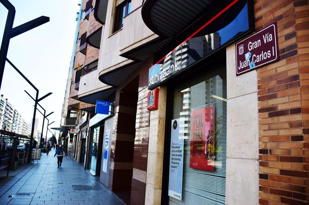 Calle con una de las placas, con pegatinas incluidas, en la que figura el nombre Gran Vía Juan Carlos I. 