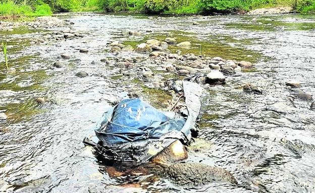 Imagen principal - Arriba, un gran plástico en el río a su paso por Logroño. Abajo, suciedad y una rueda en la zona de apertura. 