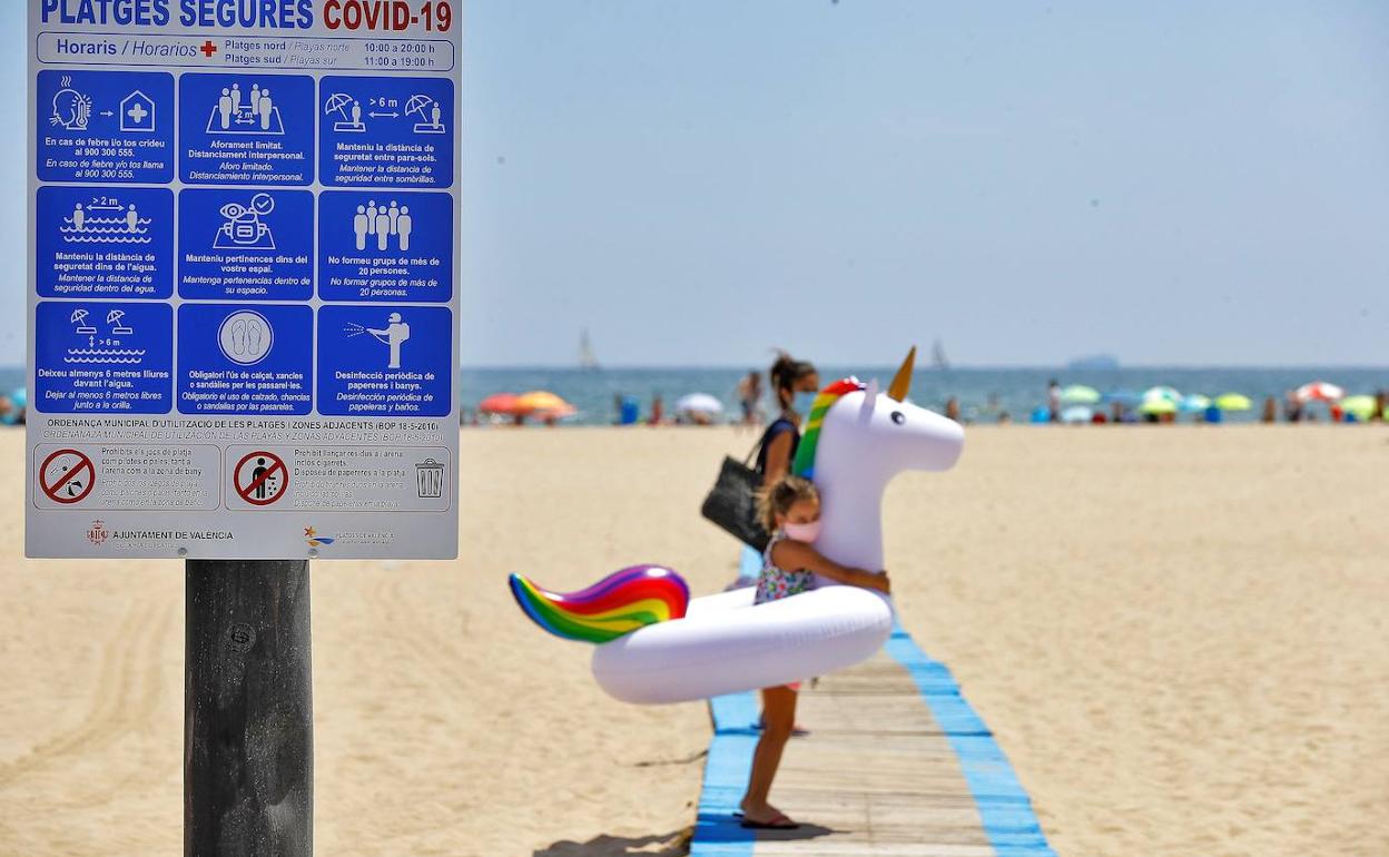 Un niña con su madre, en una playa. 