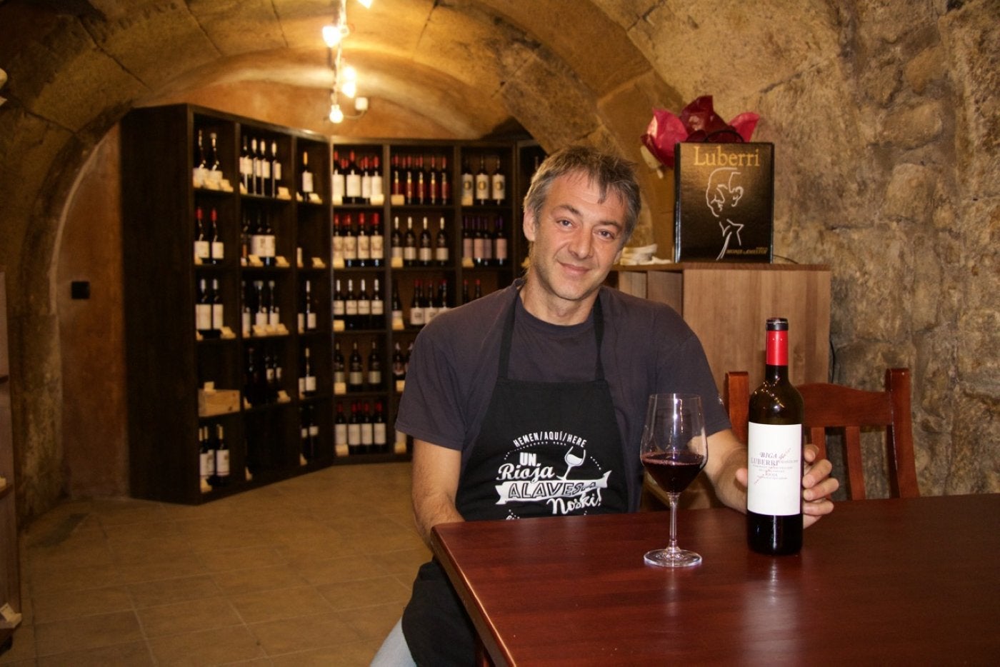 Alejandro Bañares posa junto a una copa de vino en uno de los calados del siglo XVI de su vinoteca en 'La Cueva'. 