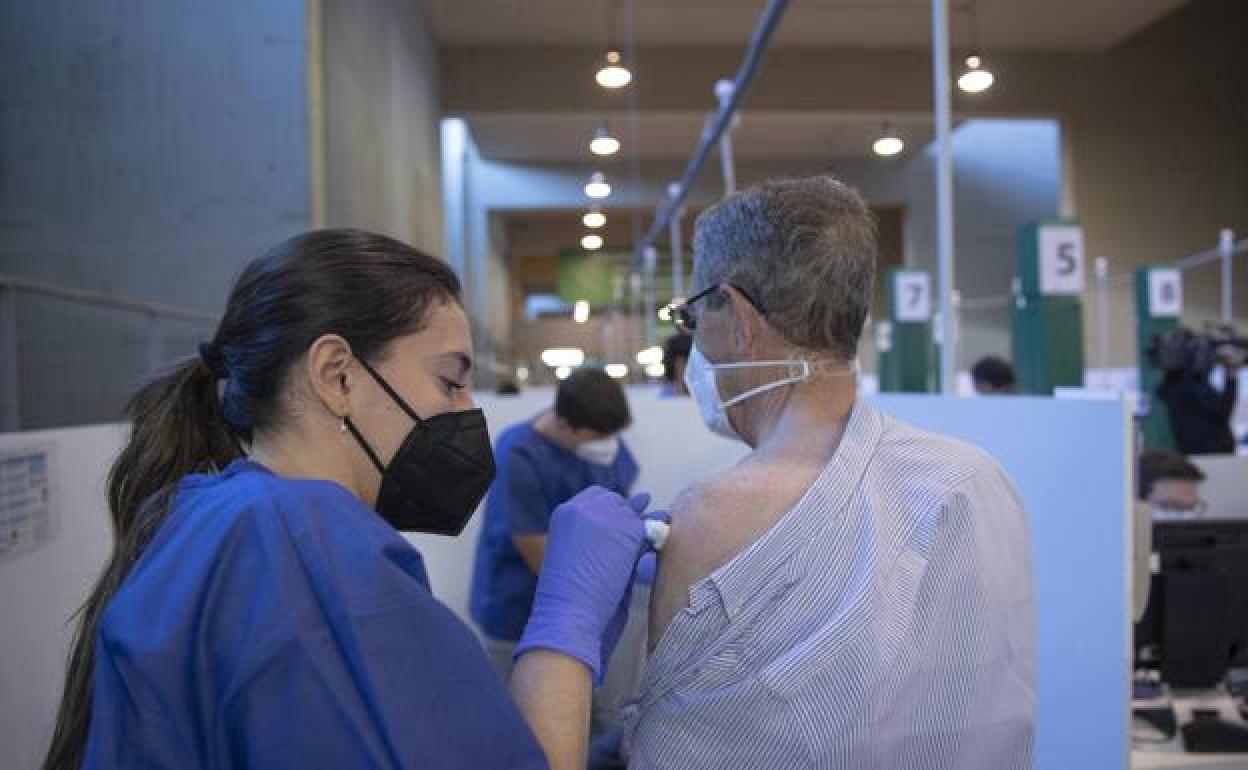 Una sanitaria vacuna a una personas. 