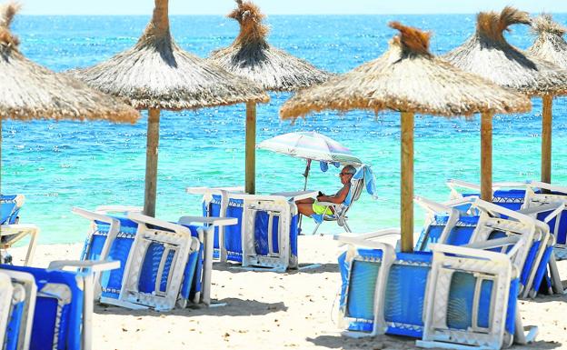 Un turista británico toma el sol en la playa mayorquina de Magaluf.