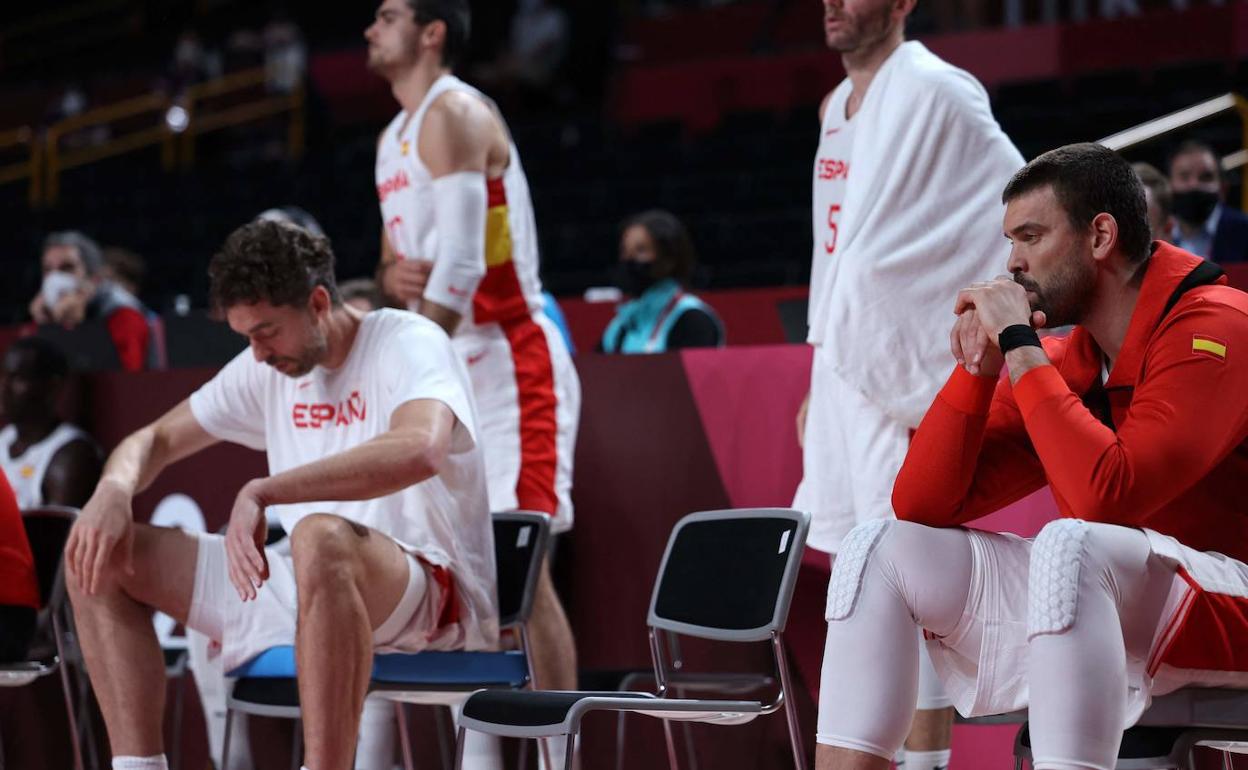 Los hermanos Gasol, cabizbajos en el banquillo.