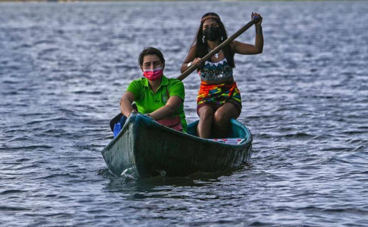 La maestra Graciela, con polo verde, se aproxima en canoa al puerto del poblado.