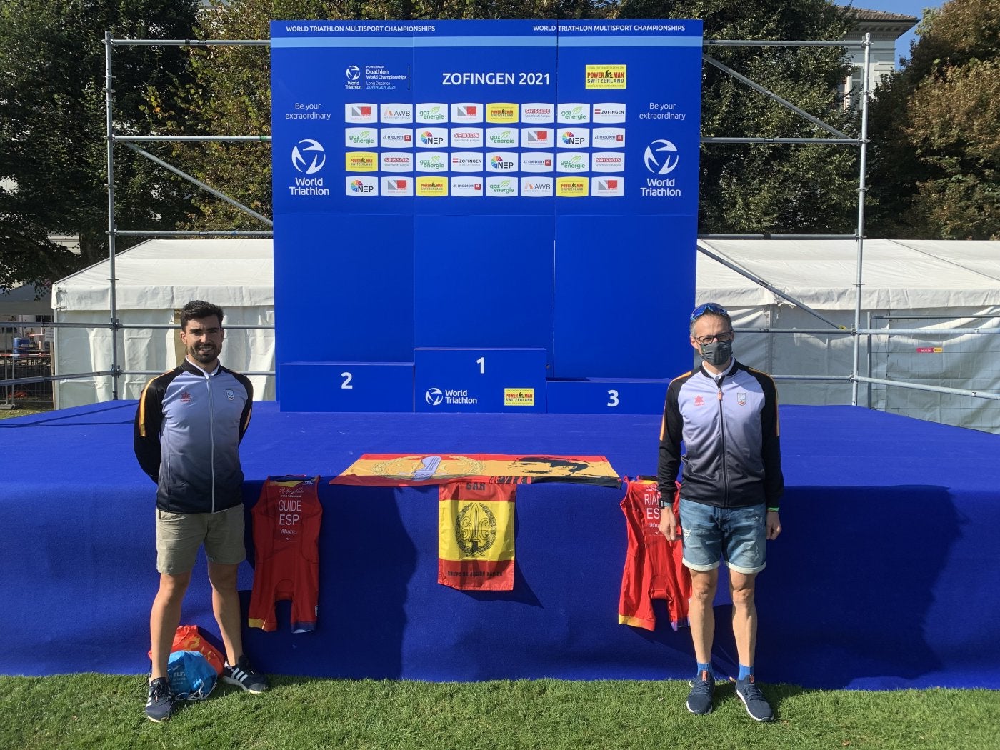 Darío Pérez y Fernando Riaño muestran camisetas junto a la bandera del GAR. 