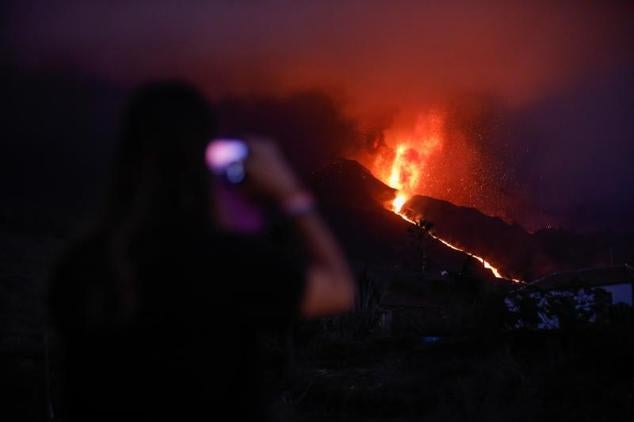 Vecinos y turistas observan el cono del volcán de Cumbre Vieja.