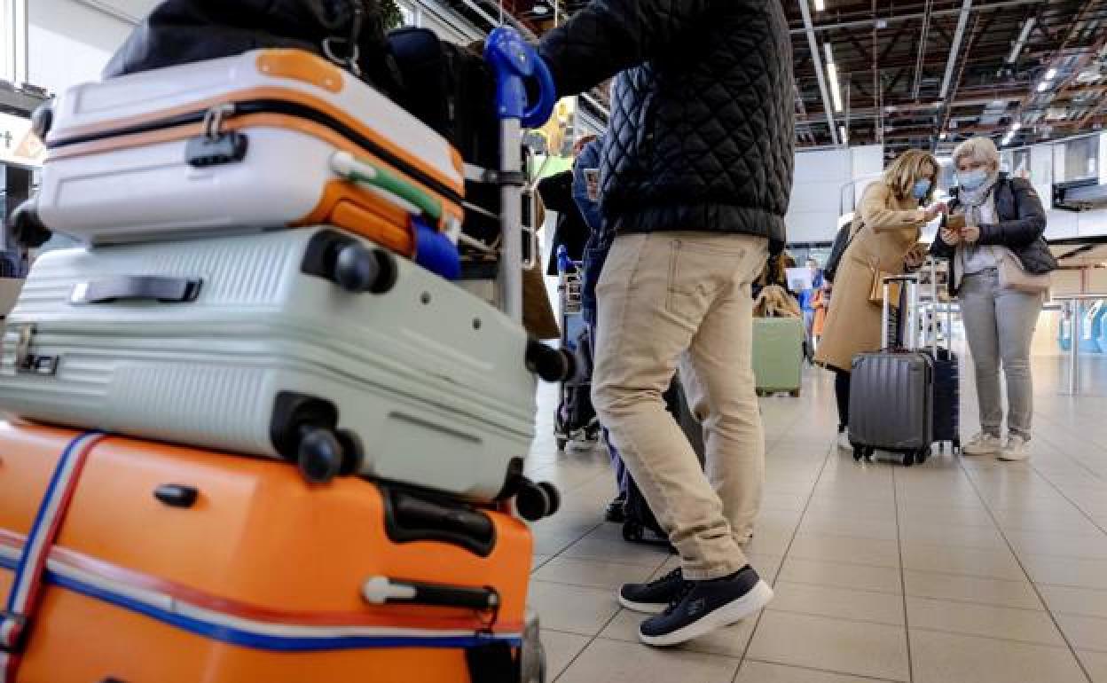 Viajeros esperando con maletas en un aeropuerto