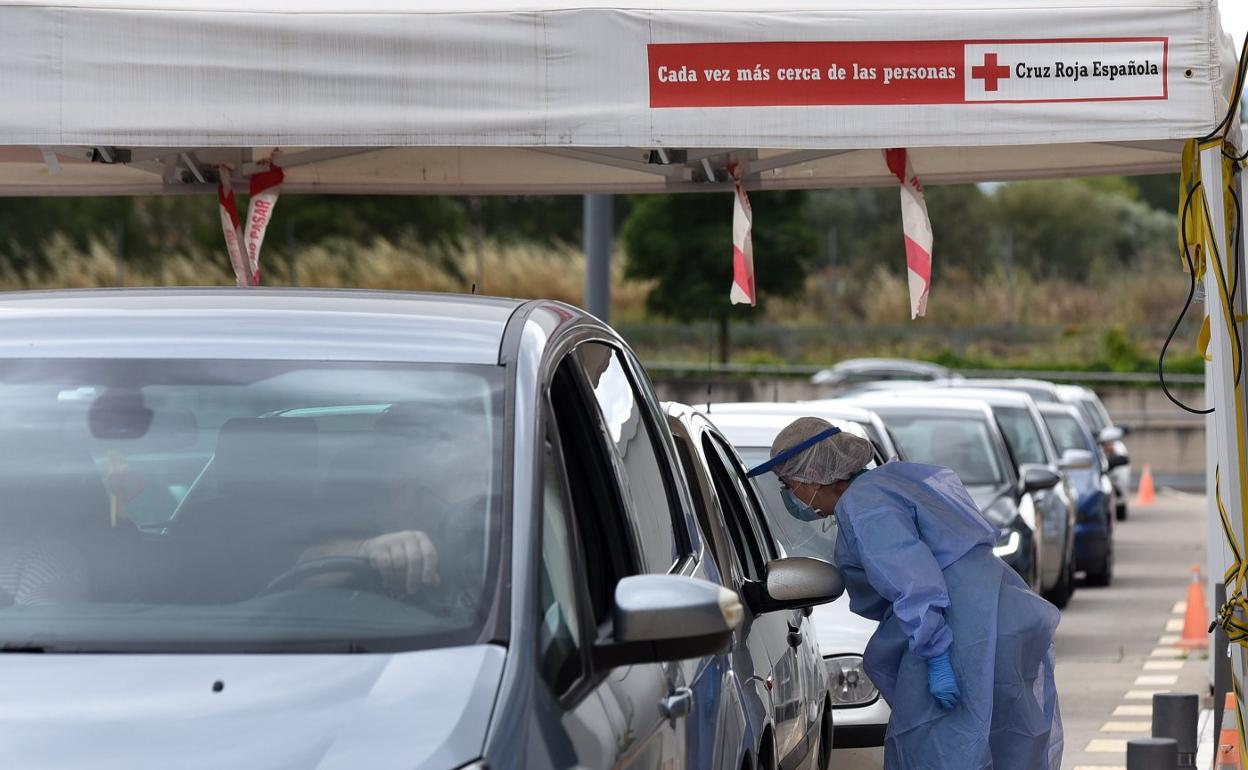 Una enfermera se dispone a realizar una prueba diagnóstica de COVID-19 a un posible paciente contagiado, en el parking del CIBIR. 