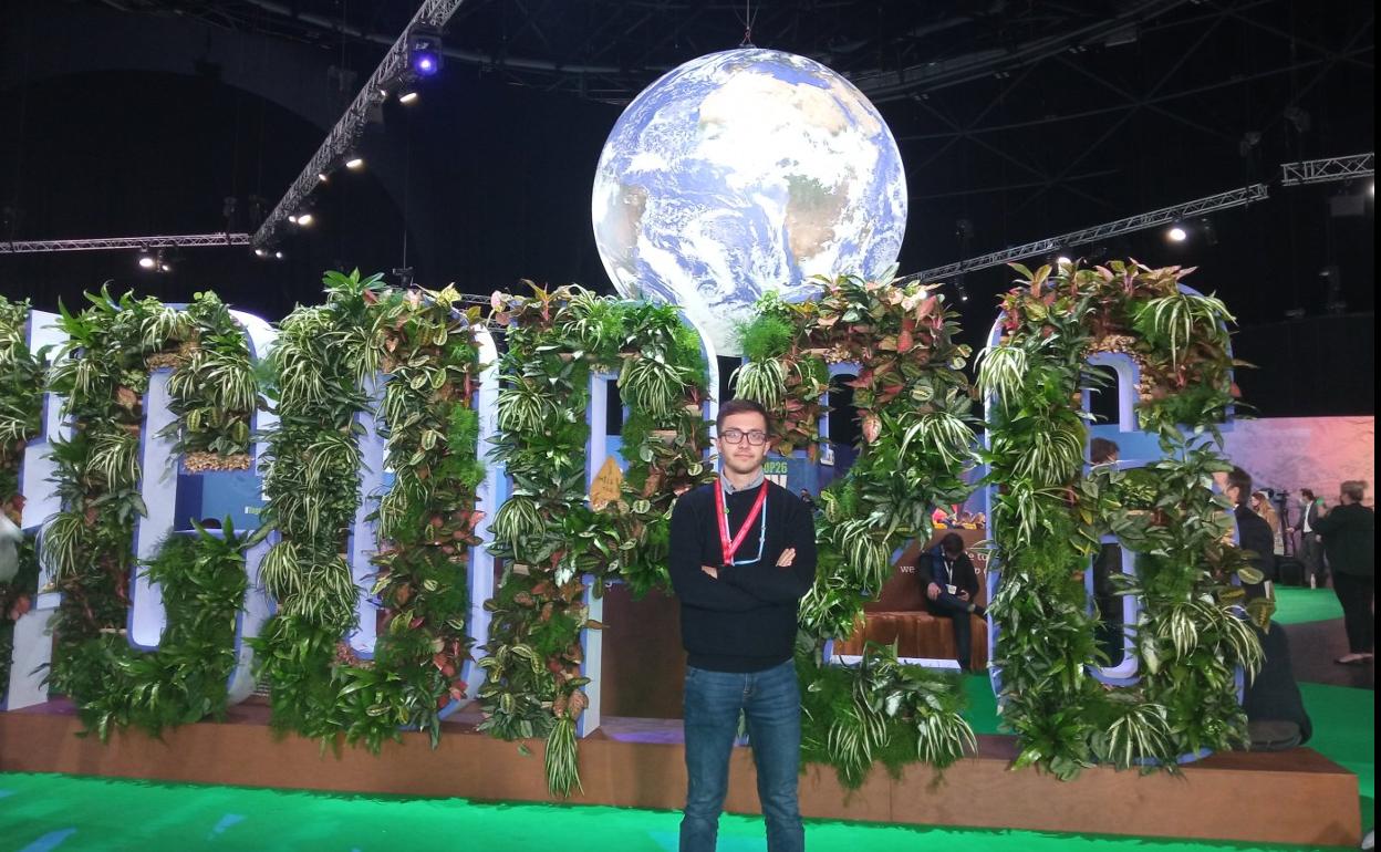 El joven alfareño Jesús Lucero, ante el logo de la COP26 de Glasgow. 