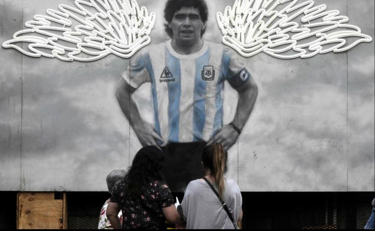 Un grupo de personas observa un mural de Maradona en Buenos Aires. 