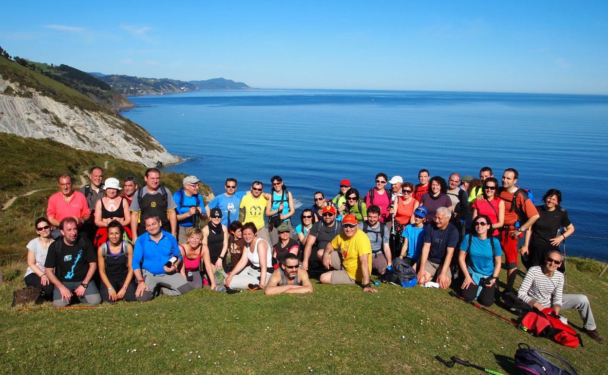 Una de sus citas anuales clásicas es su marcha con final en una sidrería, generalmente junto al mar. En la imagen, una parada para la foto de familia en la ruta entre Deva y Zumaya. 