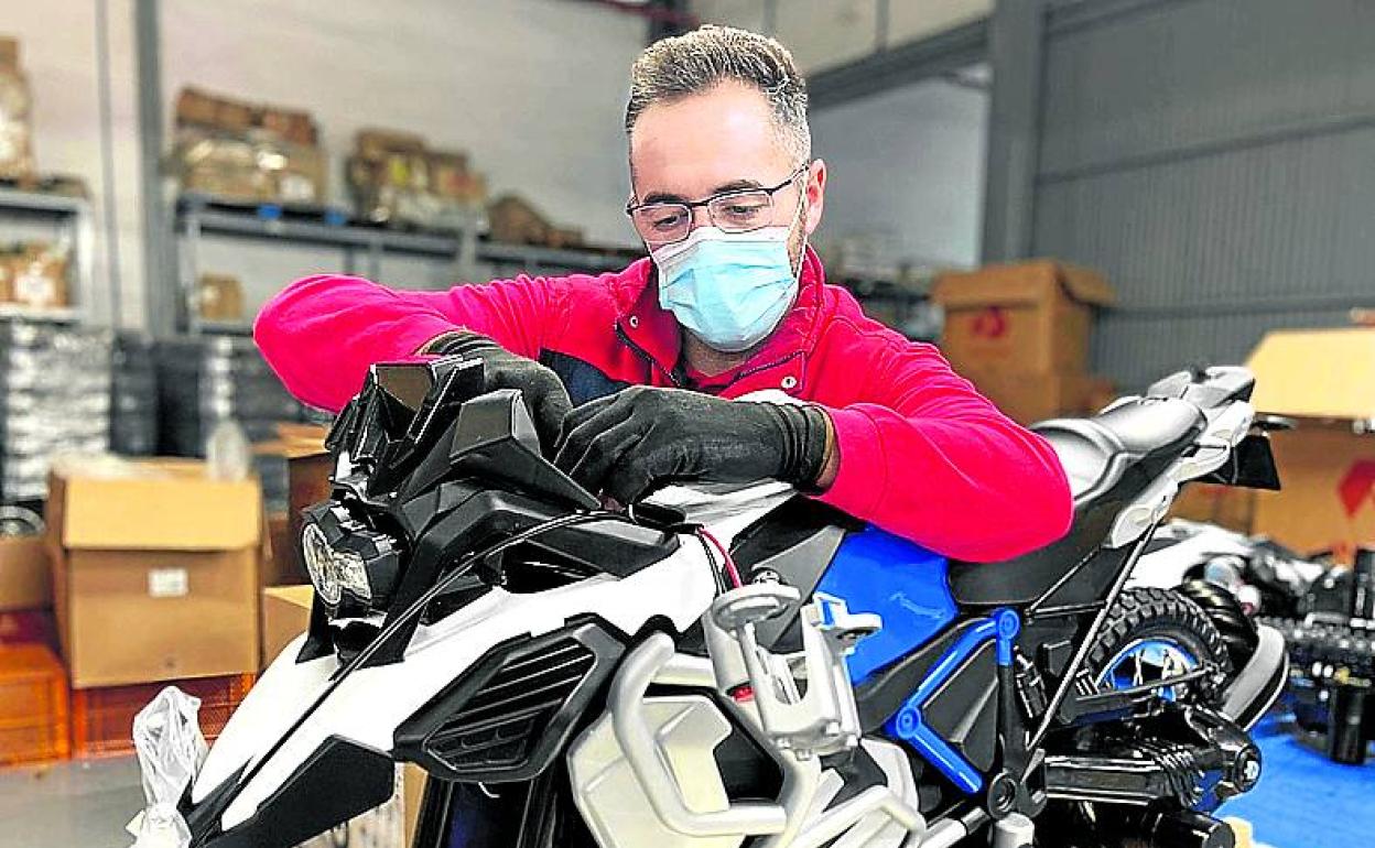 Un operario monta una réplica de una BMW GS Adventure. 