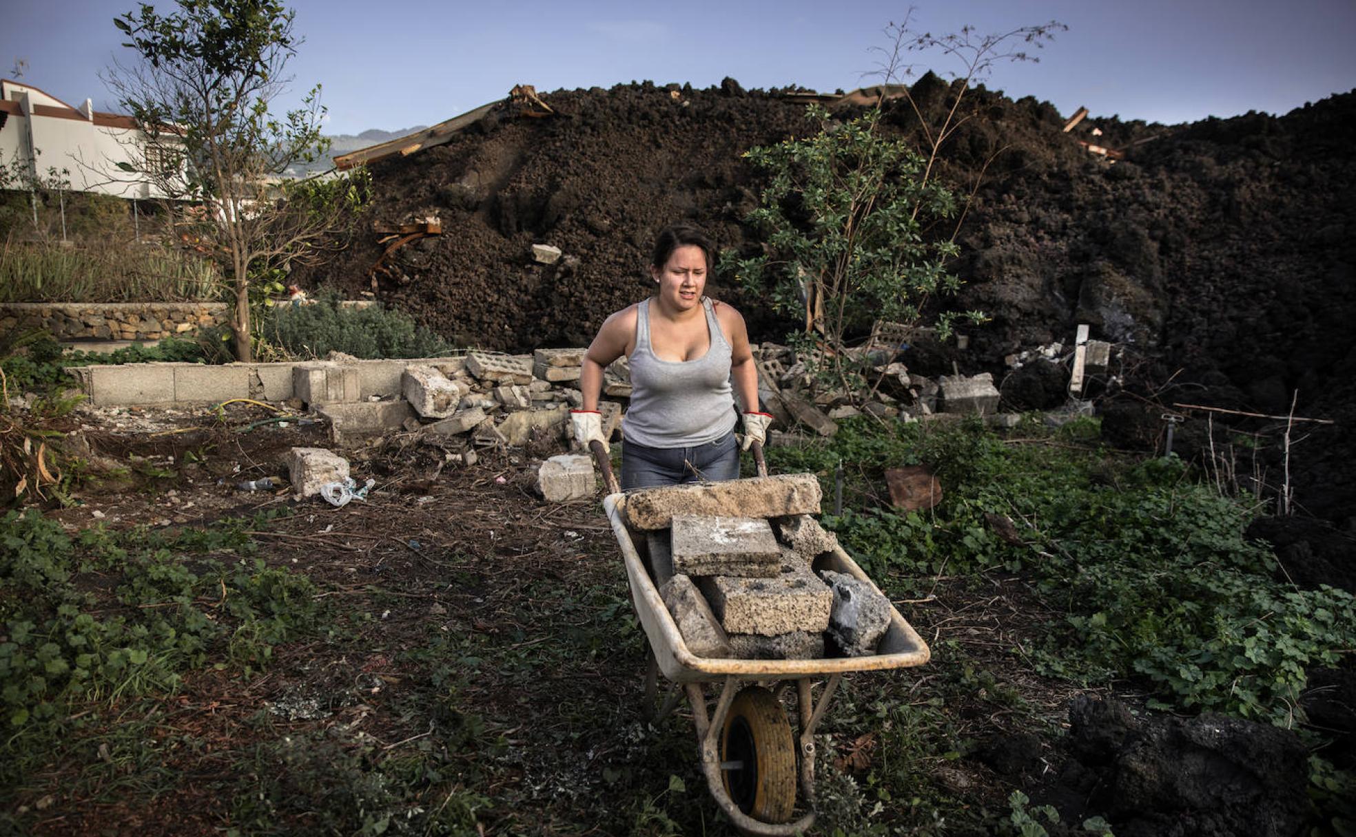 Una vecina recoje escombros del garaje, aunque su vivienda quedó intacta. 