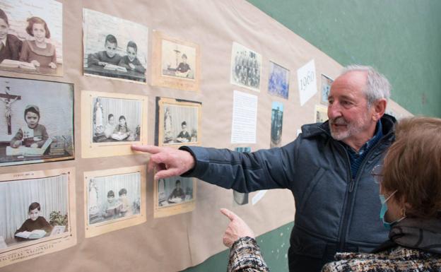 Un exalumno señala una de las fotografías en la que está de niño.