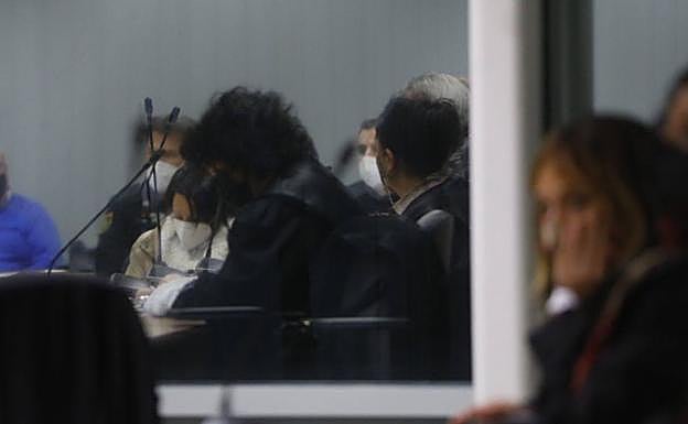 La acusada, al fondo, escucha el veredicto del jurado. 