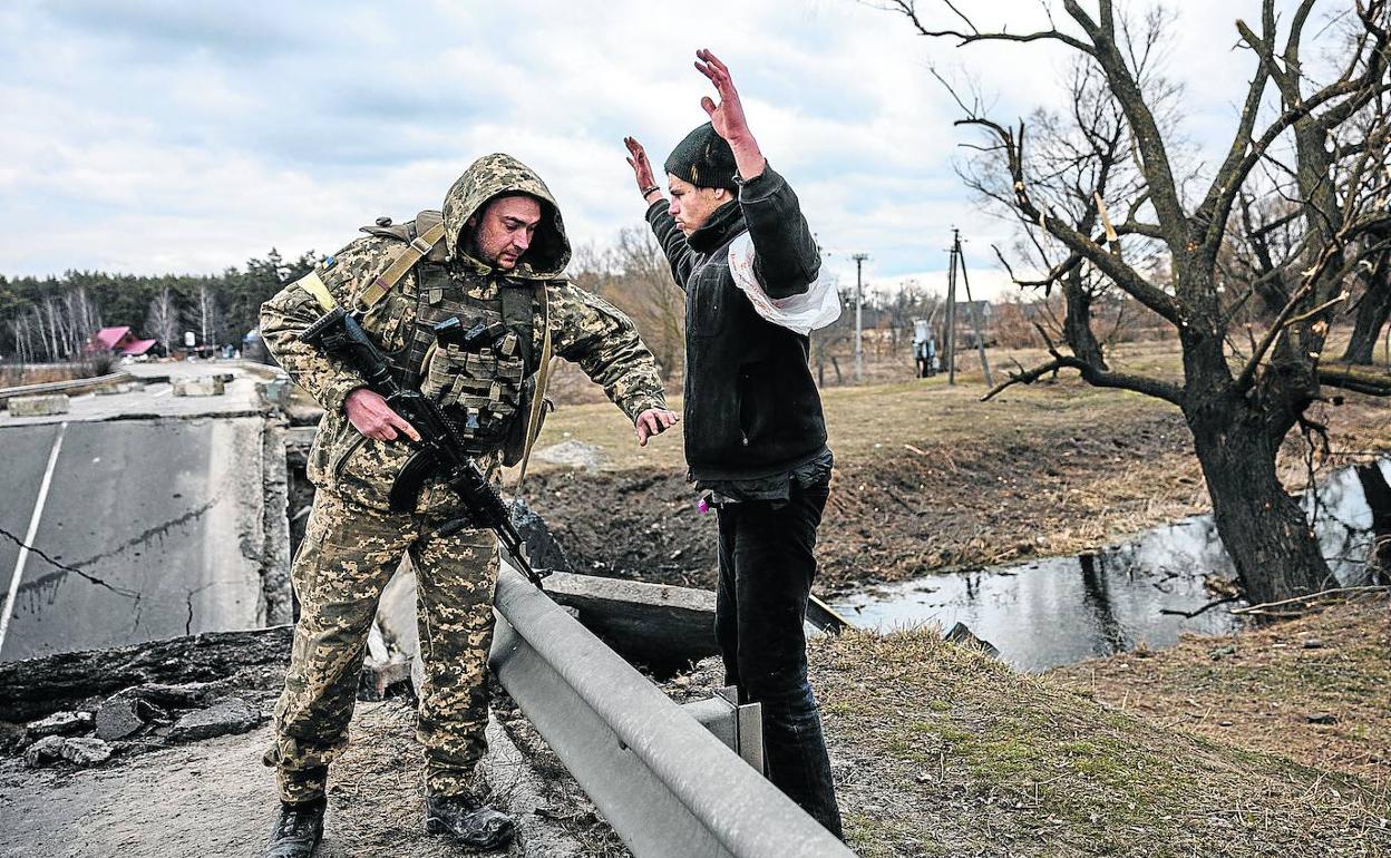 Un militar ucraniano registra a un ciudadano para comprobar que lleva bajo la chaqueta ante sus sospechas de que sea un infiltrado. 