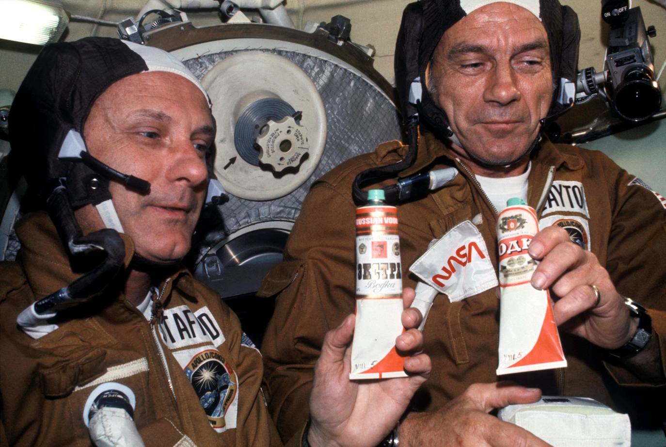 Los astronautas estadounidenses Thomas P. Stafford y Donald K. 'Deke' Slayton sostienen tubos de comida rusa durante la misión conjunta Apolo - Soyuz de 1975. El el tubo de la izquierda se puede leer "Russian vodka".