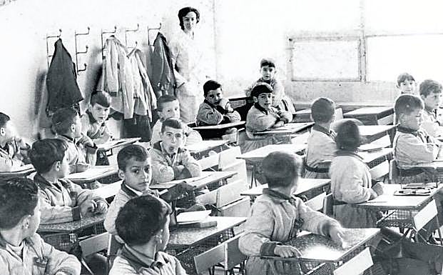 Foto de los 60 de un aula con la profesora Carmen Fernández. 