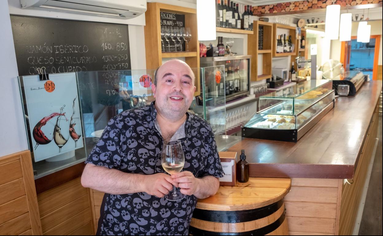 Daniel Bueno disfruta de un vino en la puerta de su local. 