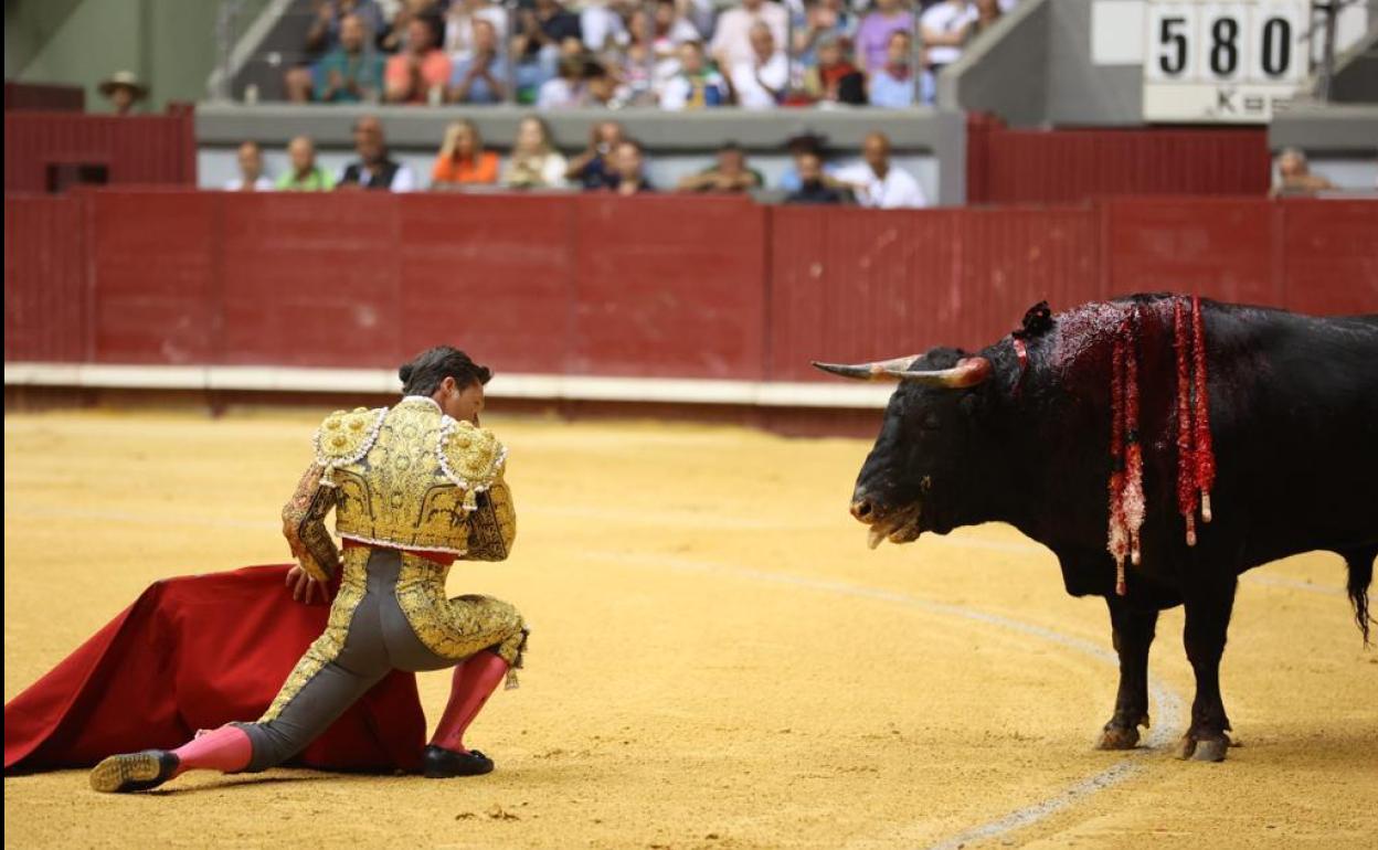 Urdiales, citando al toro, con la rodilla en la arena. 