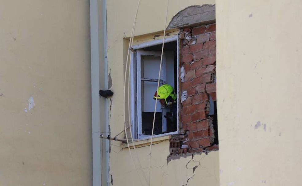 Un bombero revisa los daños en la fachada interior del inmueble