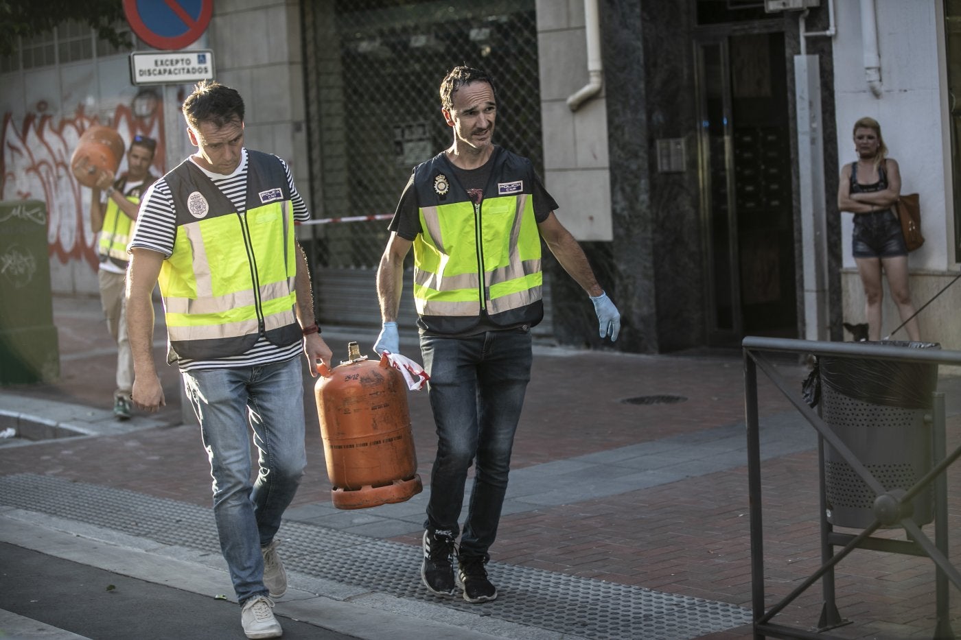 Agentes policiales, en la tarde del domingo, retirando varias bombonas de butano del edificio. 