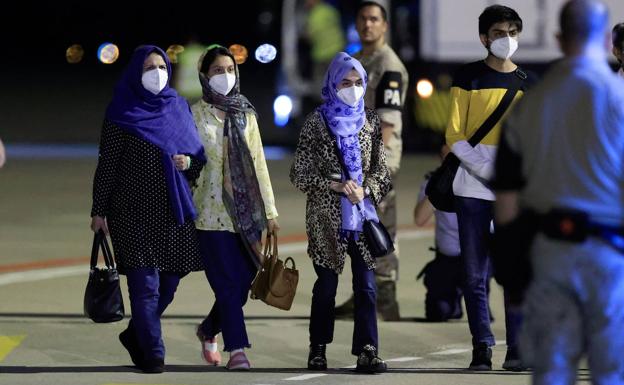 Un grupo de refugiados se dirige a pie hasta el hangar de Torrejón donde iban a ser este miércoles atendidos a su llegada a España.