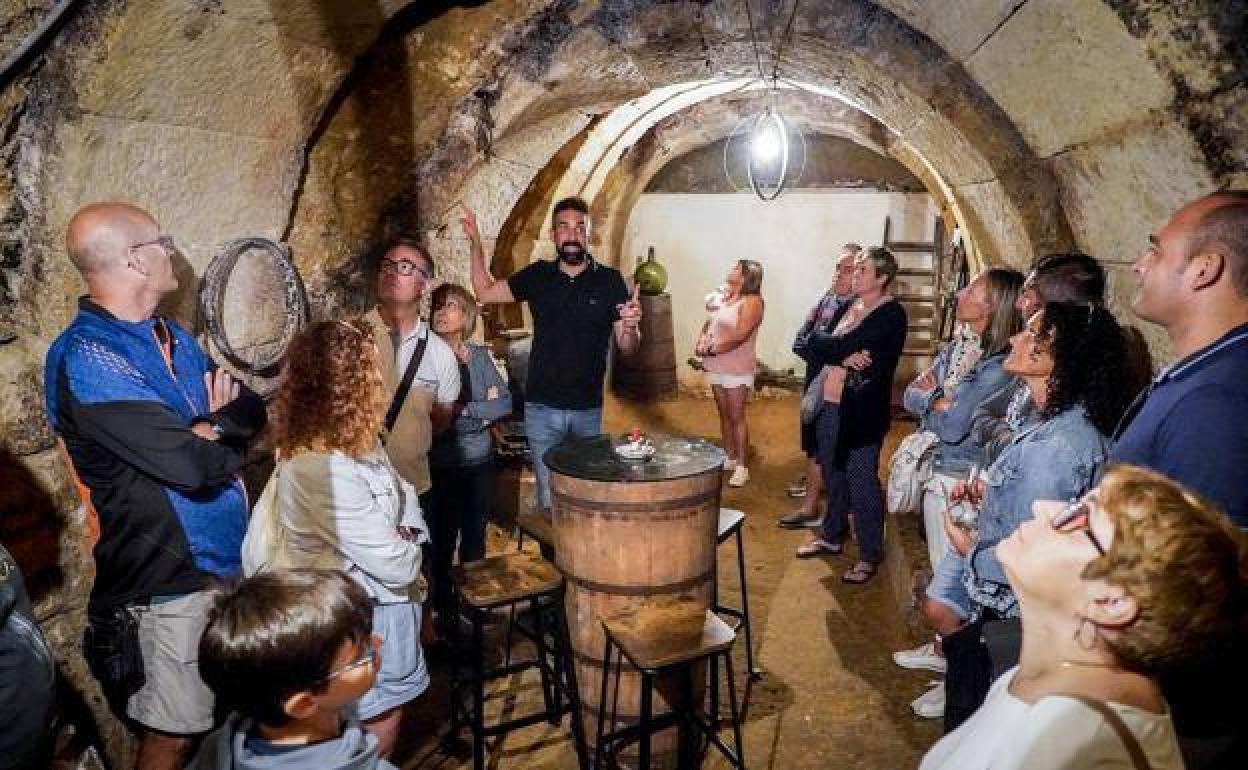 Un grupo de turistas nacionales atiende las explicaciones de Javier Ruiz, de Pepita Uva, durante una visita a una casa bodega de Laguardia.