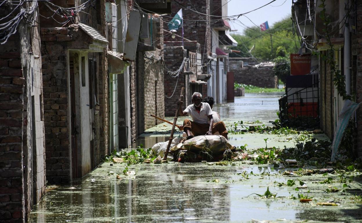 Un hombre intenta cruzar una calle inundada por las lluvias monzónicas en Hyderabad. 