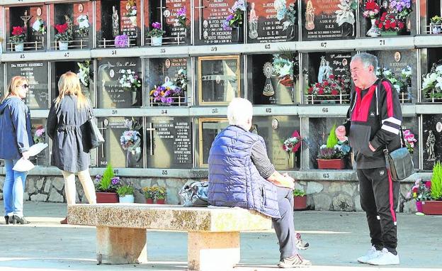 Imagen principal - El buen tiempo animó también a los najerinos a acudir a un camposanto repleto de flores para honrar a sus seres queridos. En Santo Domingo hubo ramos de flores y melancolía. En la última imagen, tres mujeres depositan flores en Calahorra.