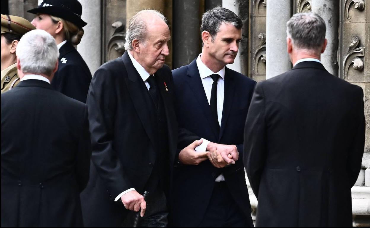 Don Juan Carlos es ayudado por un asistente a acceder a la Abadía de Westminter al funeral por Isabel II. 